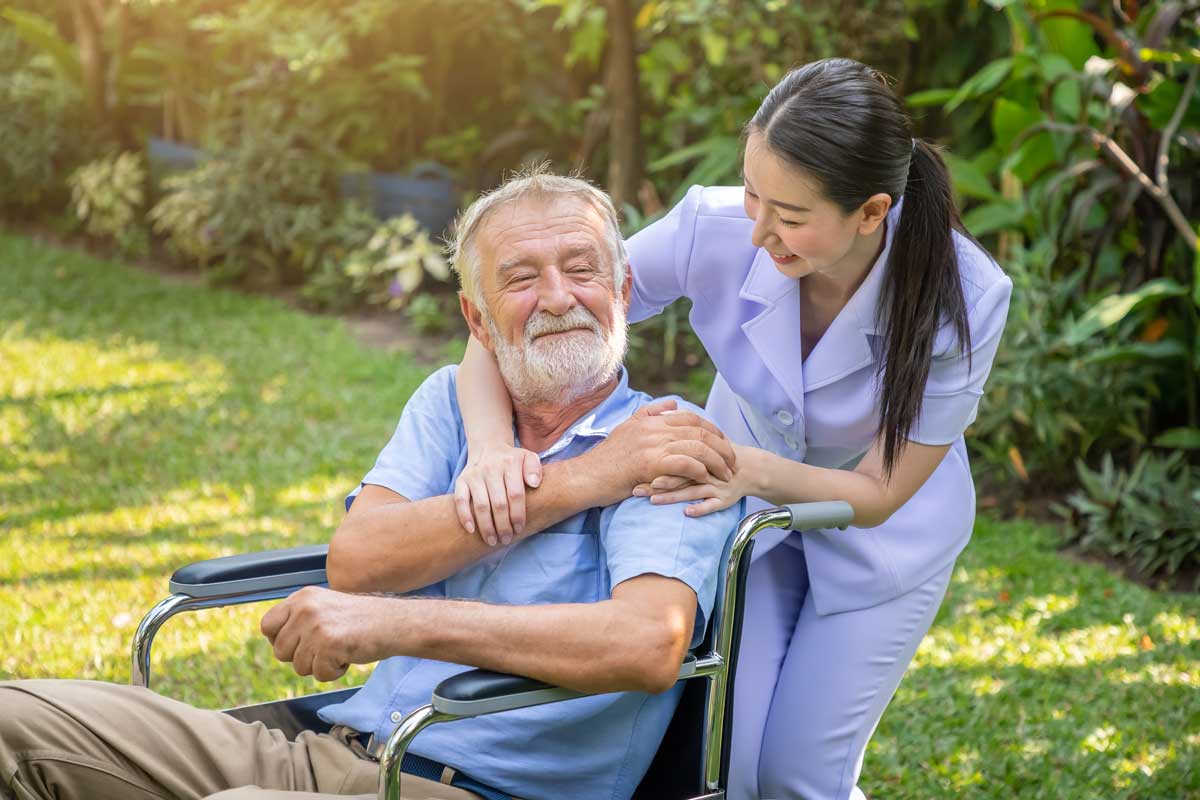 happy-nurse-holding-elderly-man-hand-wheelchair-garden-nur1sing-home